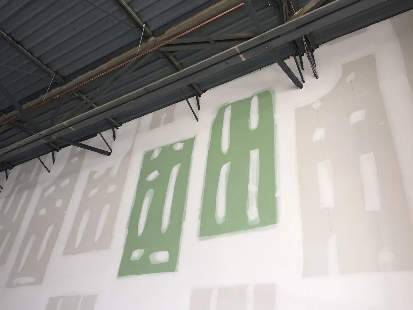 Drywall panels hung on a commercial building ceiling