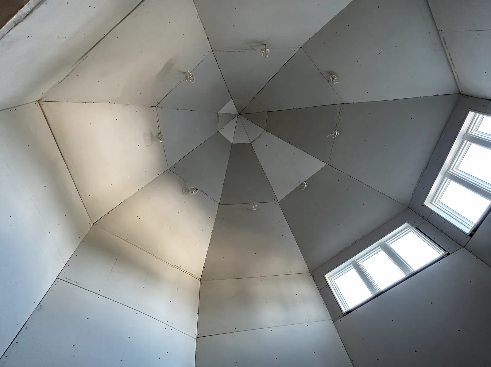 Drywall panels hung in a custom turret ceiling, ready for taping